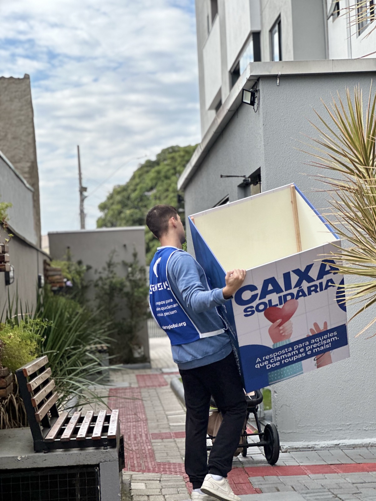 Voluntário do Instituto Senders entregando a Caixa Solidária em um prédio de Balneário Camboriú